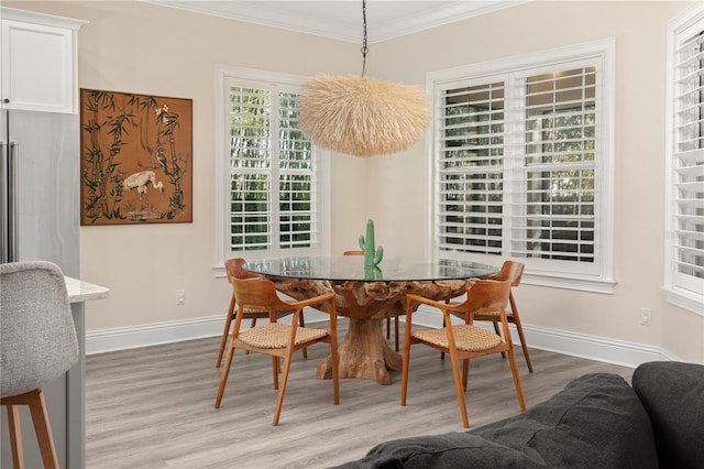 dining space featuring crown molding and light wood-type flooring