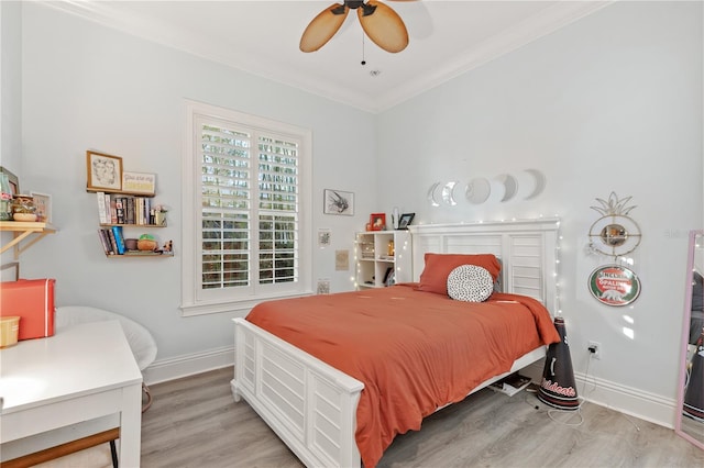 bedroom featuring crown molding, light hardwood / wood-style floors, and ceiling fan