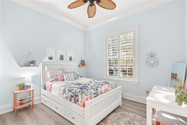 bedroom featuring wood-type flooring, ceiling fan, and crown molding