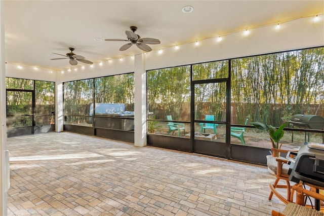 unfurnished sunroom featuring ceiling fan