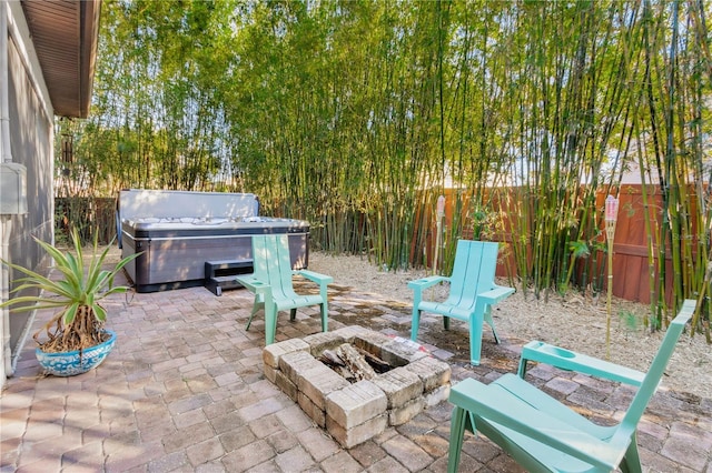 view of patio featuring a hot tub and an outdoor fire pit