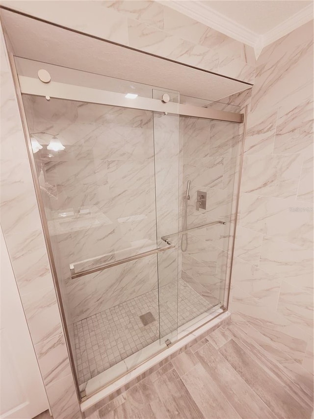 bathroom with an enclosed shower and crown molding