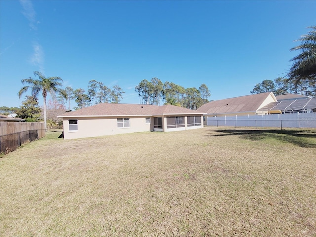 back of property featuring a yard and a sunroom