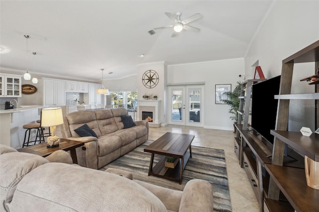 living room with ornamental molding, lofted ceiling, light tile patterned floors, and french doors