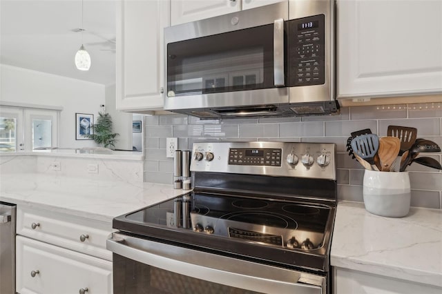 kitchen with tasteful backsplash, white cabinetry, and appliances with stainless steel finishes