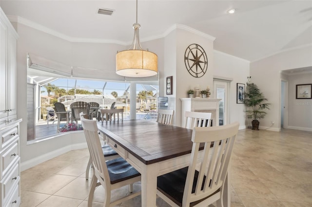 dining area featuring light tile patterned floors and crown molding