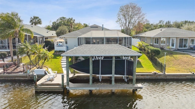 view of dock with a lawn and a water view