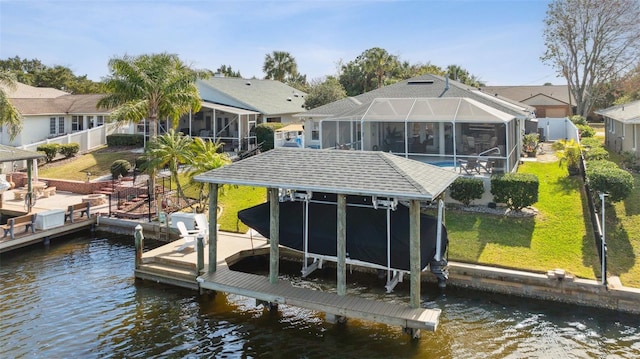 view of dock with a water view, glass enclosure, and a lawn