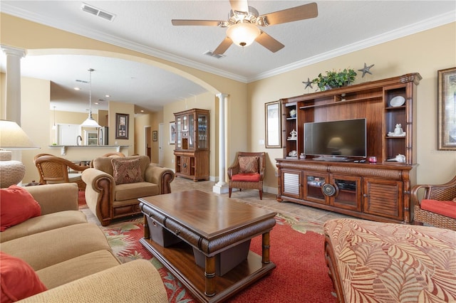 living room with ceiling fan, ornamental molding, a textured ceiling, light tile patterned flooring, and ornate columns