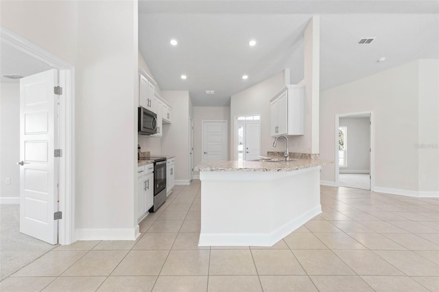 kitchen with sink, light tile patterned floors, stainless steel appliances, and white cabinets