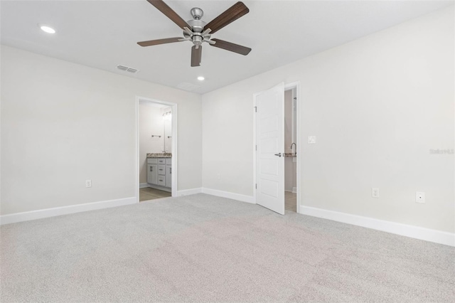 unfurnished bedroom with light carpet, ensuite bath, and ceiling fan