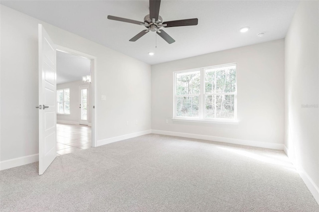 spare room featuring light carpet and ceiling fan