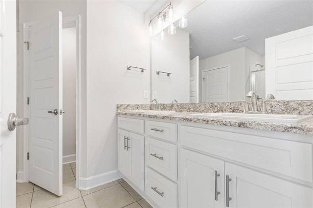 bathroom featuring tile patterned flooring, vanity, and walk in shower