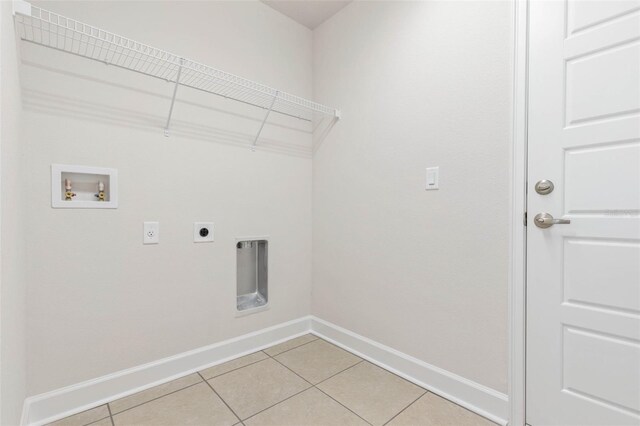 laundry area featuring electric dryer hookup, washer hookup, and light tile patterned floors