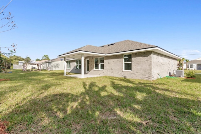 rear view of house with a yard, central AC, and a patio