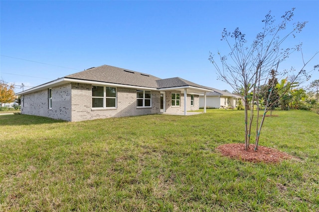 back of house featuring a lawn and a patio