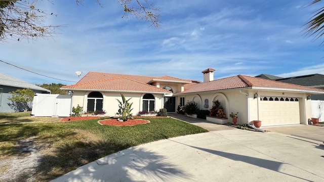 mediterranean / spanish-style house featuring a garage and a front yard