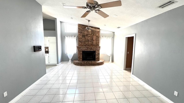 unfurnished living room featuring lofted ceiling, light tile patterned floors, a textured ceiling, and a brick fireplace