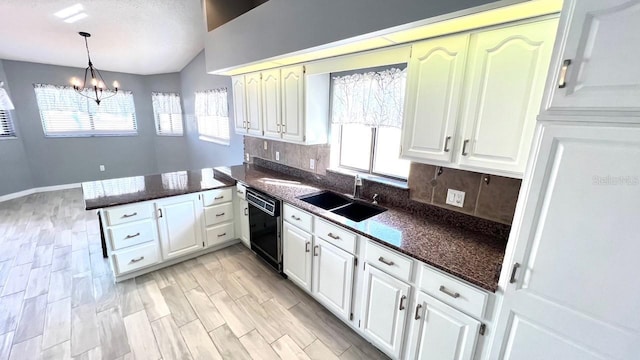 kitchen featuring dishwasher, sink, white cabinets, and kitchen peninsula