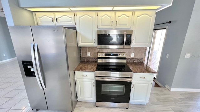 kitchen featuring backsplash, light tile patterned floors, white cabinets, and appliances with stainless steel finishes