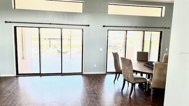 dining space featuring dark wood-type flooring and a healthy amount of sunlight