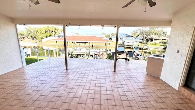 view of patio / terrace with a boat dock, ceiling fan, and a water view