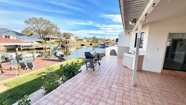 view of patio / terrace featuring a water view, a dock, and grilling area