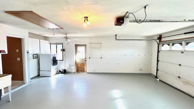 garage with a garage door opener and independent washer and dryer