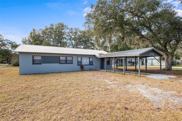 ranch-style home featuring a front lawn and a carport