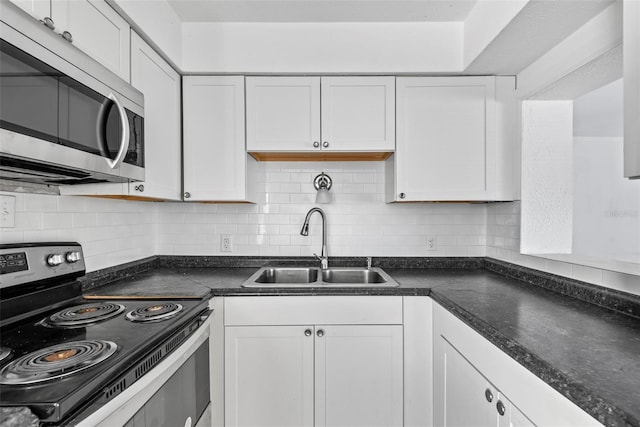 kitchen featuring stainless steel appliances, sink, white cabinets, and backsplash