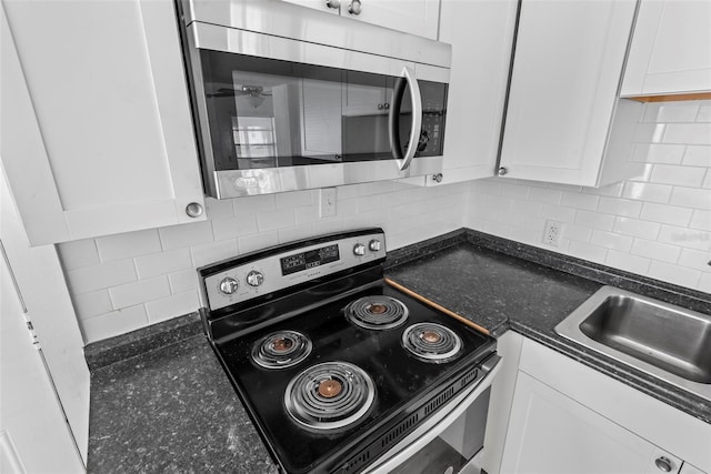 kitchen with tasteful backsplash, white cabinetry, and appliances with stainless steel finishes