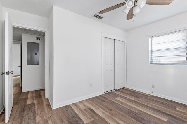 unfurnished bedroom with ceiling fan, dark hardwood / wood-style flooring, and a closet