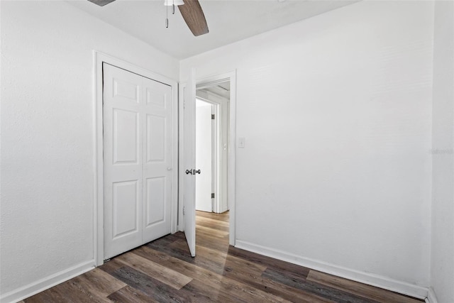 unfurnished bedroom featuring ceiling fan, dark hardwood / wood-style flooring, and a closet