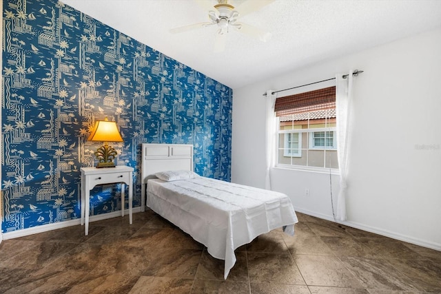 bedroom with ceiling fan, a textured ceiling, and dark tile patterned floors