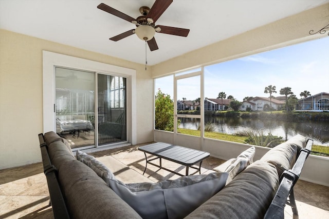 sunroom / solarium with ceiling fan and a water view