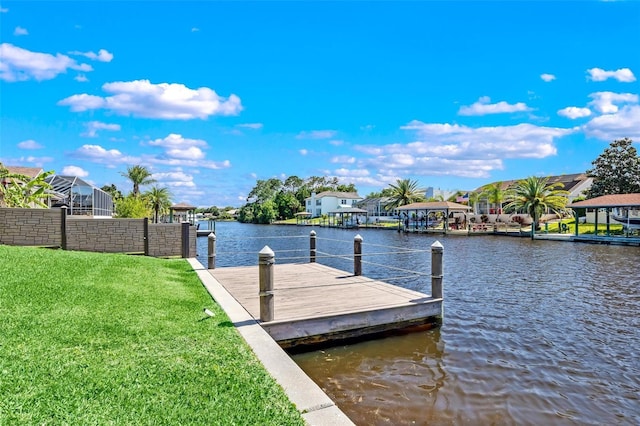 dock area with a lawn and a water view