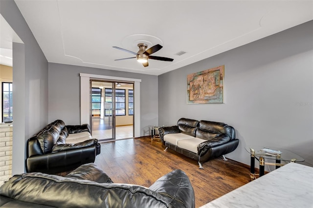 living room featuring ceiling fan, a wealth of natural light, and wood-type flooring