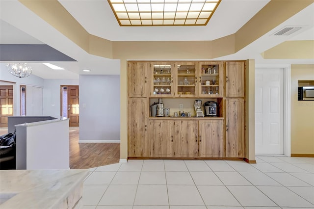 kitchen with light tile patterned floors and a notable chandelier