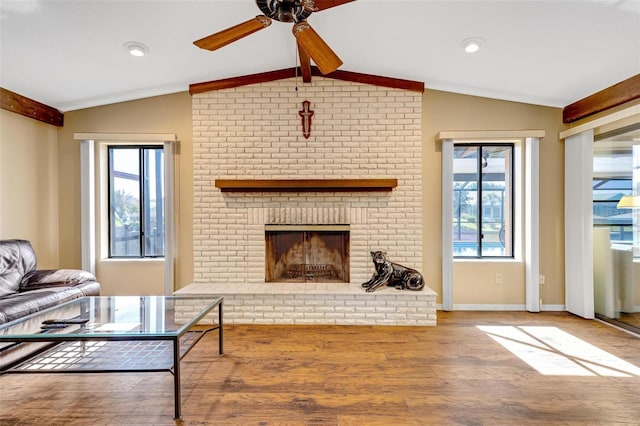 living room with a brick fireplace, wood-type flooring, and lofted ceiling with beams