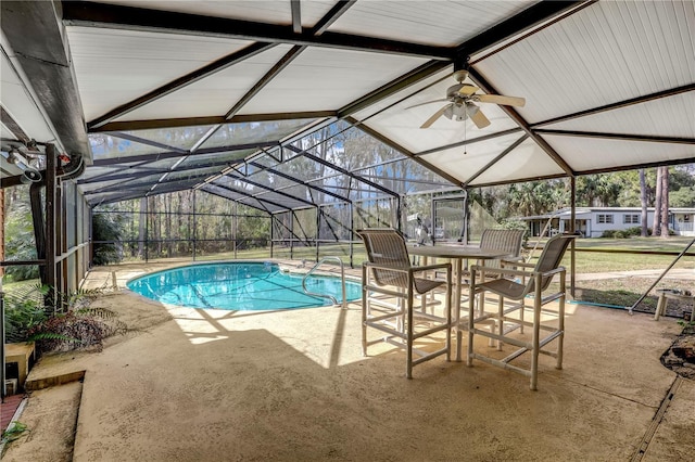 view of pool with ceiling fan, a lanai, and a patio