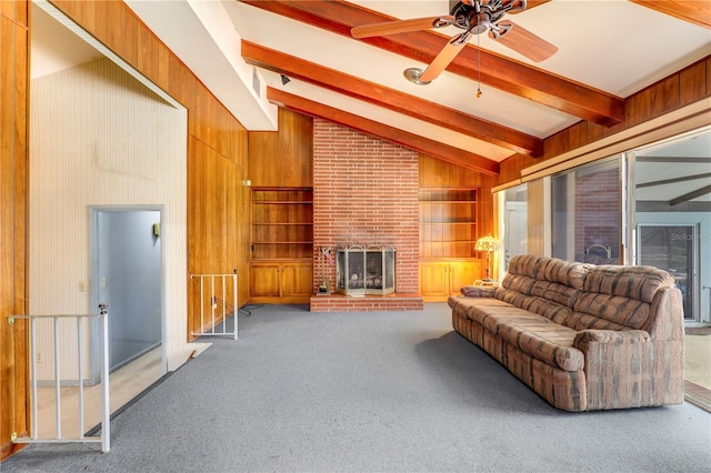 living room with beamed ceiling, a fireplace, carpet, and wood walls