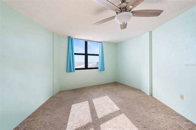 unfurnished room featuring carpet and a textured ceiling