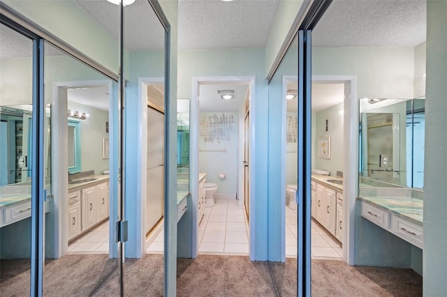 bathroom with a textured ceiling, tile patterned floors, and toilet