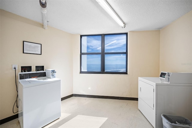 laundry room with separate washer and dryer and a textured ceiling