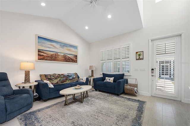 living room featuring lofted ceiling, light hardwood / wood-style floors, and ceiling fan