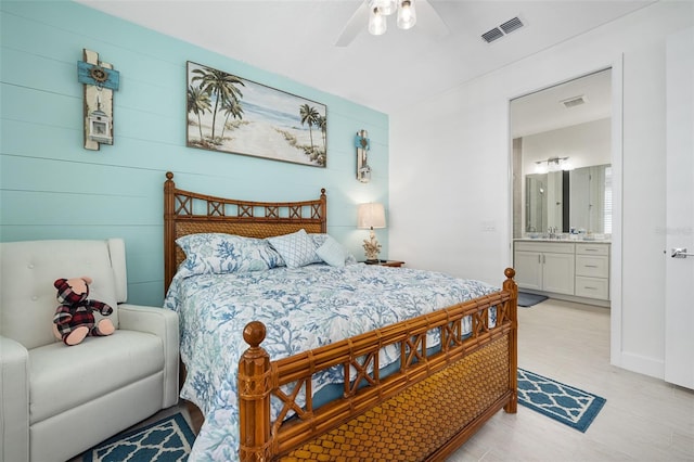 bedroom with ceiling fan, connected bathroom, and sink