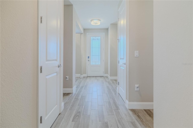 corridor featuring baseboards and wood tiled floor