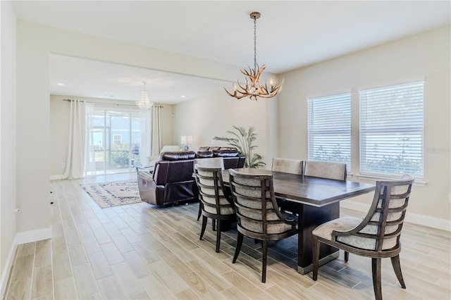 dining space with recessed lighting, baseboards, an inviting chandelier, and light wood finished floors