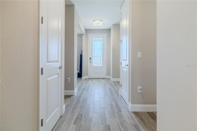 corridor featuring baseboards and wood tiled floor