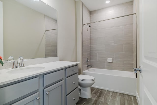 bathroom with wood finish floors, shower / bath combination, vanity, and toilet